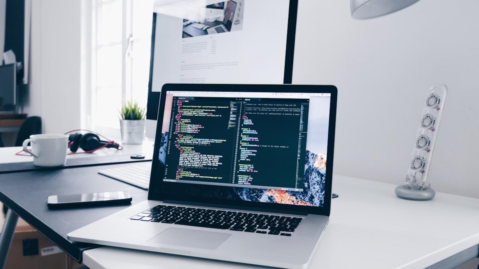 Laptop on a desk showing code in an editor